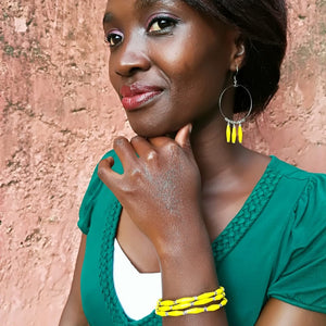 Hand made yellow design paper bead bracelet made out of recycled paper in Uganda by principles of fair trade, ethical and sustainable fashion, by Finnish brand, Agulu Paper Beads. Eettinen keltainen käsintehty design rannekoru, joka on tehty kierrätyspaperista reilun kaupan periaattein työllistämällä Ugandalaisia naisia.