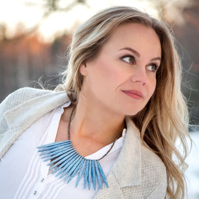 Light blue hand made design paper bead necklace made out of recycled paper in Uganda by principles of fair trade, ethical and sustainable fashion, empowering women of post war area, by Finnish / Scandinavian brand, Agulu Paper Beads. Eettinen vaaleansininen käsintehty design kaulakoru, joka on tehty kierrätyspaperista reilun kaupan periaattein työllistämällä kehitysmaan nasia.